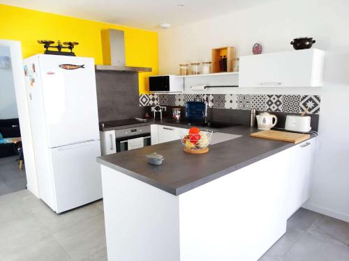 une cuisine avec des armoires blanches et un réfrigérateur blanc dans l'établissement Quai 31 saint Gilles Croix de Vie, à Dameraucourt