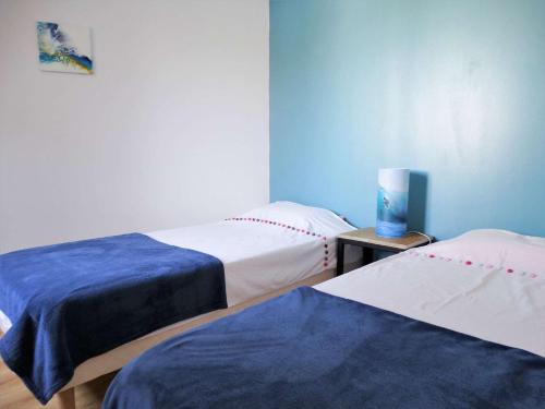 Cette chambre comprend deux lits et une lampe sur une table. dans l'établissement Quai 31 saint Gilles Croix de Vie, à Dameraucourt