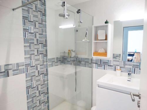 une salle de bain blanche avec une douche et un lavabo dans l'établissement Quai 31 saint Gilles Croix de Vie, à Dameraucourt