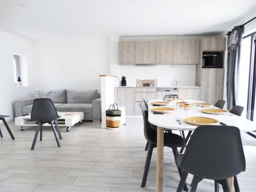 une salle à manger avec une table et des chaises et une cuisine dans l'établissement Méridien Saint Gilles Croix de Vie, à Saint-Gilles-Croix-de-Vie
