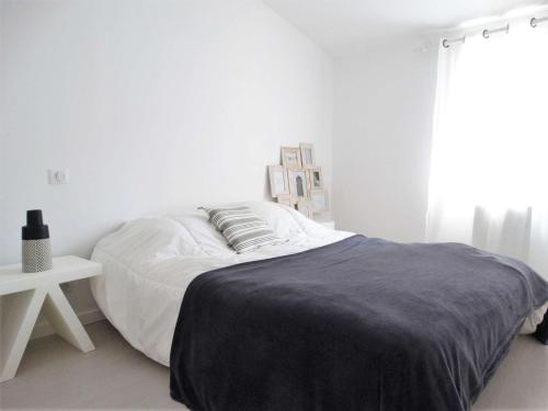 une chambre blanche avec un grand lit et une table dans l'établissement Méridien Saint Gilles Croix de Vie, à Saint-Gilles-Croix-de-Vie