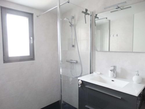 une salle de bain blanche avec un lavabo et une douche dans l'établissement Méridien Saint Gilles Croix de Vie, à Saint-Gilles-Croix-de-Vie