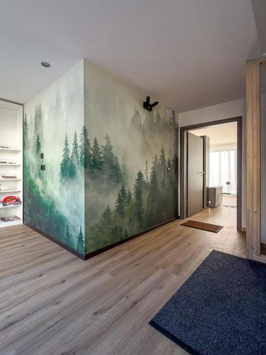 a room with a wall with a painting of trees at La Clef des Franches in Saignelégier