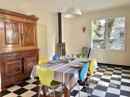 une salle à manger avec une table et des chaises jaunes et bleues dans l'établissement Les Trolls Saint Hilaire de Riez, à Sion-sur-lʼOcéan