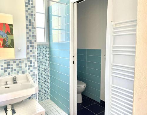 une salle de bain avec un lavabo et des toilettes dans l'établissement Les Trolls Saint Hilaire de Riez, à Sion-sur-lʼOcéan