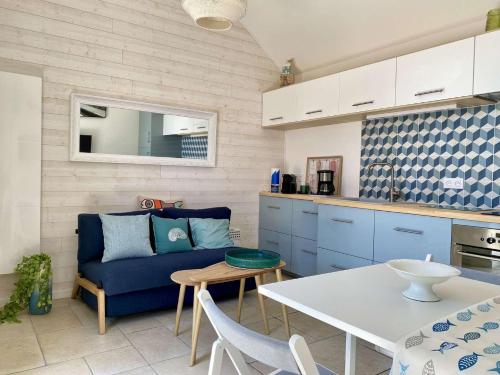 un salon avec un canapé bleu et une table dans l'établissement Micki Saint Gilles Croix de Vie, à Les Bussolleries