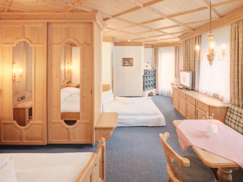 a hotel room with two beds and a table at Hotel Magdalena Mayrhofen in Mayrhofen