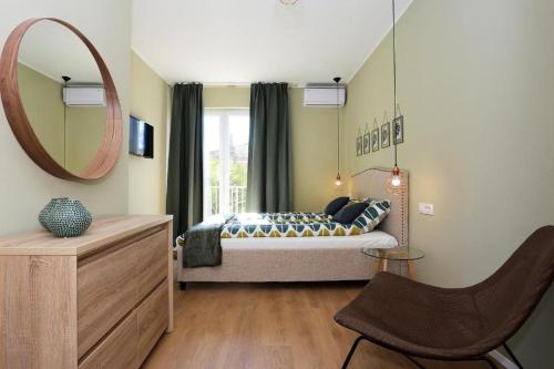a bedroom with a bed with a mirror and a chair at Prestige design rooms in Zadar