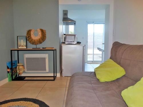 - un salon avec un canapé et un réfrigérateur dans l'établissement Dauphin Saint Gilles Croix de Vie, à Les Bussolleries