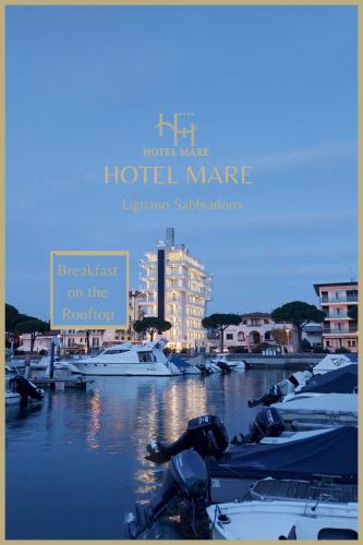 a sign for a hotel marina with boats in the water at Hotel Mare in Lignano Sabbiadoro