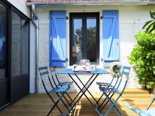 une table bleue et deux chaises sur la terrasse dans l'établissement Joséphine Saint Gilles Croix de Vie, à Les Bussolleries