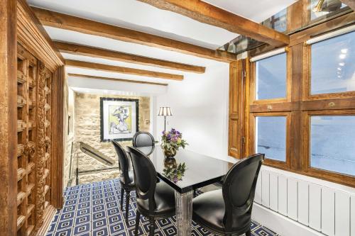 une salle à manger avec une table, des chaises et des fenêtres dans l'établissement Akipik, à Paris