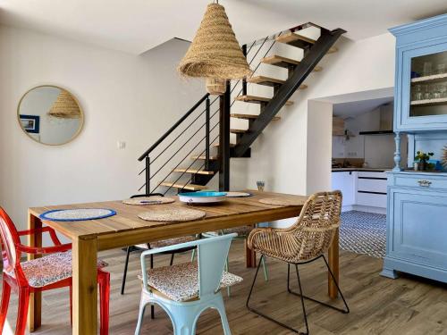 une salle à manger avec une table et des chaises en bois dans l'établissement Géranium Saint Gilles Croix de Vie, à Les Bussolleries