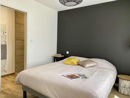 - une chambre avec un lit et un livre dans l'établissement Géranium Saint Gilles Croix de Vie, à Les Bussolleries