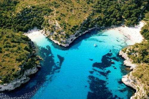an aerial view of a river with blue water at Kampaoh Menorca in Cala Galdana