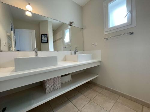une salle de bain avec deux lavabos et un grand miroir dans l'établissement Maison 6 pièces 10 couchages Saint Georges d'Oléron SGO000-069, à Saint-Georges-dʼOléron