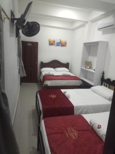 a group of four beds in a room at Hotel Santa Bárbara Mompox Doble in Mompos