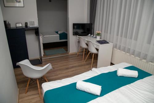 a hotel room with a bed and a table and chairs at Spirit House Eger in Eger
