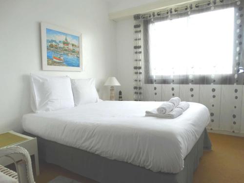 a bedroom with a large white bed with towels on it at Goélette Saint Gilles Croix de Vie in Le Sablais