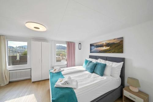 a bedroom with a bed and two windows at book2stay - Apartments Herisau in Herisau