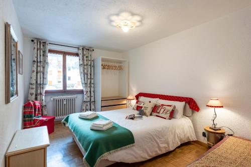 a bedroom with a bed with a green and white blanket at Montagne E Coccole - Happy Rentals in Pré-Saint-Didier