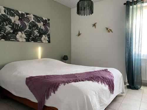 une chambre avec un lit et un tableau au mur dans l'établissement Harpon - Saint Gilles Croix de Vie, à Saint-Gilles-Croix-de-Vie