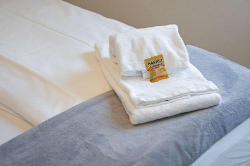 a white towel sitting on top of a bed at book2stay - Apartments Herisau in Herisau