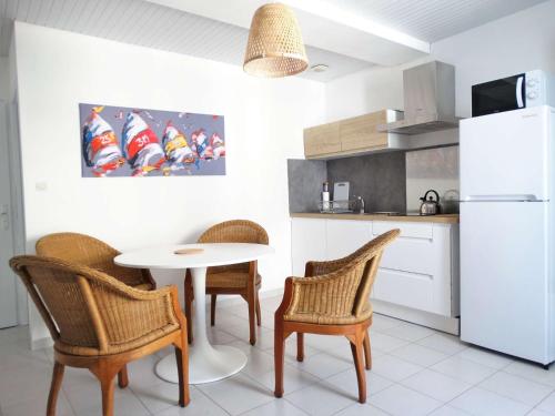une cuisine avec une table et des chaises et un réfrigérateur blanc dans l'établissement Hauban - Saint Gilles Croix de Vie, à Saint-Gilles-Croix-de-Vie