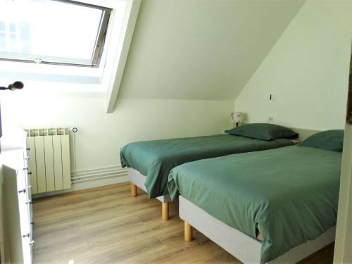 two twin beds in a room with a window at Le Mistral Saint Gilles Croix de Vie in Les Bussolleries