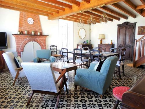 une salle à manger avec une table et des chaises et une cheminée dans l'établissement Le Mistral Saint Gilles Croix de Vie, à Les Bussolleries