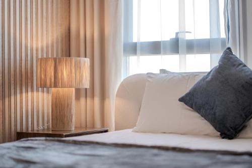 a bedroom with a bed with a lamp and a window at Amazing 1BDR New Building by Blue Cloud Holidays in Sharjah Intl