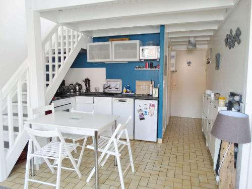 - une cuisine avec une table blanche et des appareils électroménagers blancs dans l'établissement Pirogue Saint Gilles Croix de Vie, à Saint-Gilles-Croix-de-Vie