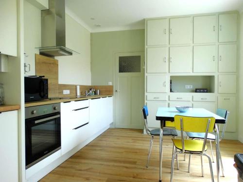 une cuisine avec des armoires blanches et une table et des chaises dans l'établissement Javeline Saint Hilaire de Riez, à Sion-sur-lʼOcéan