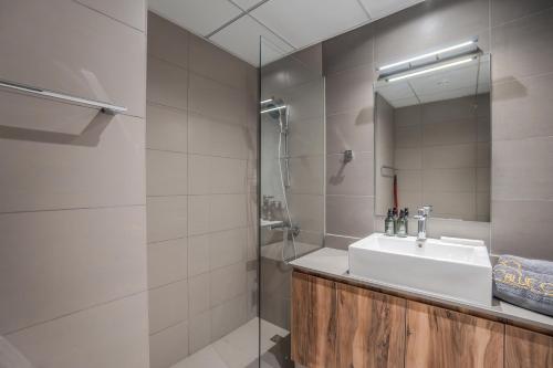 a bathroom with a sink and a shower at Amazing 1BDR New Building by Blue Cloud Holidays in Sharjah Intl