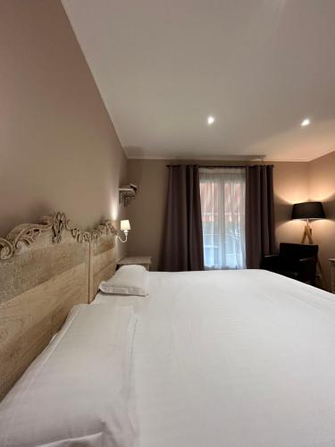 a bedroom with a large white bed and a window at La Lune De Mougins - Hotel & Spa in Mougins