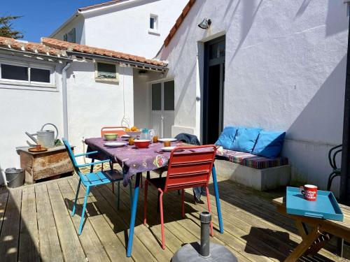 un patio avec une table et des chaises sur une terrasse dans l'établissement Youyou Saint Gilles Croix de Vie, à Les Bussolleries