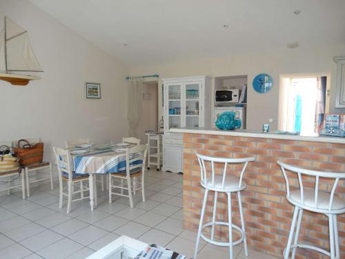 une cuisine avec une table et des chaises dans une cuisine dans l'établissement La Grénette Saint Gilles Croix de Vie, à Saint-Gilles-Croix-de-Vie