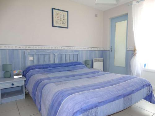une chambre avec un grand lit avec une couverture bleue dans l'établissement La Grénette Saint Gilles Croix de Vie, à Saint-Gilles-Croix-de-Vie