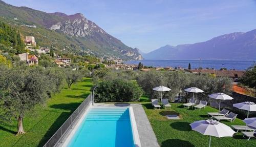a resort with a swimming pool and umbrellas at PELACA' Resort in Gargnano
