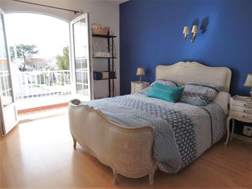 a bedroom with a large bed with blue walls at Littoral Saint Gilles Croix de Vie in Saint-Gilles-Croix-de-Vie