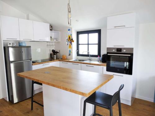 une cuisine avec une table en bois et un réfrigérateur dans l'établissement Marinière Saint Gilles Croix de Vie, à Saint-Gilles-Croix-de-Vie