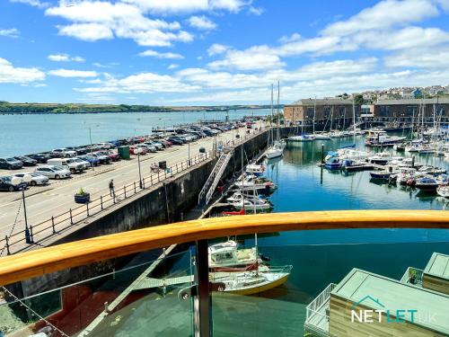a marina with alot of boats in the water at Orion House - Luxury Apartment overlooking Milford Marina, Pembrokeshire in Milford Haven