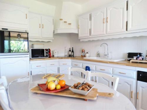 une cuisine blanche avec une assiette de fruits sur une table dans l'établissement Langouste Saint Hilaire de Riez, à Sion-sur-lʼOcéan