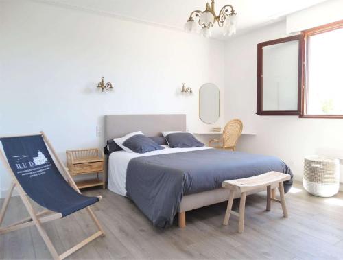une chambre blanche avec un lit et une chaise dans l'établissement Langouste Saint Hilaire de Riez, à Sion-sur-lʼOcéan
