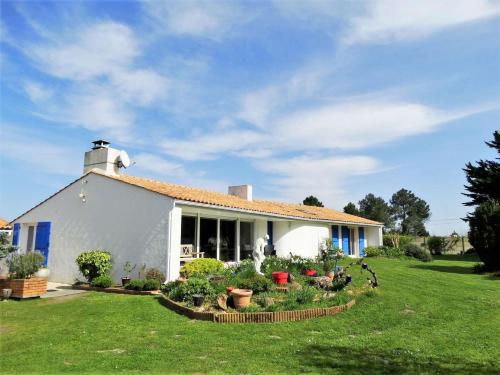 une maison blanche avec un jardin en face dans l'établissement Les Treilles Saint Hilaire de Riez, à Notre-Dame-de-Riez
