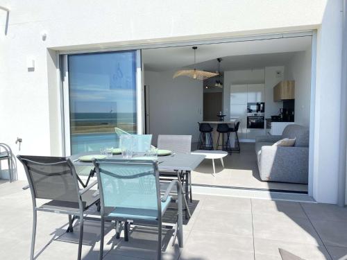 d'un salon et d'une terrasse avec une table et des chaises. dans l'établissement Evasion Saint Hilaire de Riez, à Sion-sur-lʼOcéan