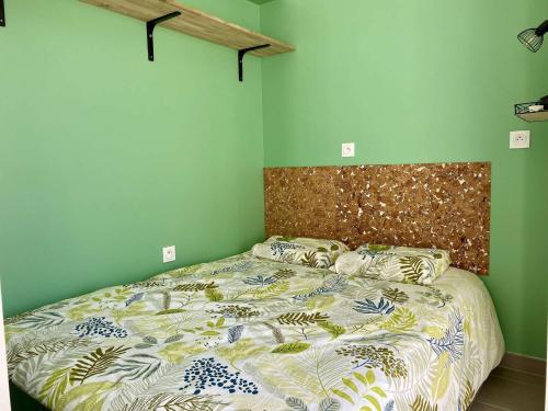 une chambre avec un grand lit avec une tête de lit en bois dans l'établissement Phare Saint Gilles Croix de Vie, à Saint-Gilles-Croix-de-Vie