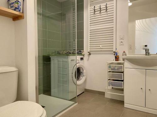 une salle de bain avec une machine à laver et un lavabo dans l'établissement Phare Saint Gilles Croix de Vie, à Saint-Gilles-Croix-de-Vie