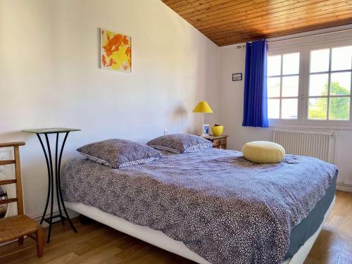 Un dormitorio con una cama con un edredón azul. en Rivage - Saint Hilaire de Riez, en Les Bussolleries