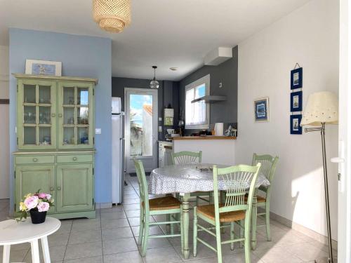 une cuisine et une salle à manger avec une table et des chaises dans l'établissement Salamandre - Saint Hilaire de Riez, à Saint-Hilaire-de-Riez